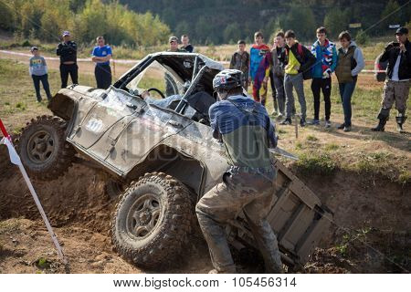 RUSSIA, PUSHKINO -?? 20 SEP, 2014: Rally team member is helping to pull off-road vehicle at Rainforest Challenge Russia Autumn 2014 PRO-X.