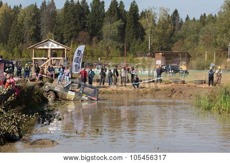 RUSSIA, PUSHKINO -?? 20 SEP, 2014: Off-road vehicle is driving in pond at Rainforest Challenge Russia Autumn 2014 PRO-X at sunny day.