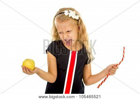 Little Pretty Female Child Choosing Dessert Holding Unhealthy But Tasty Red Candy Licorice And Apple