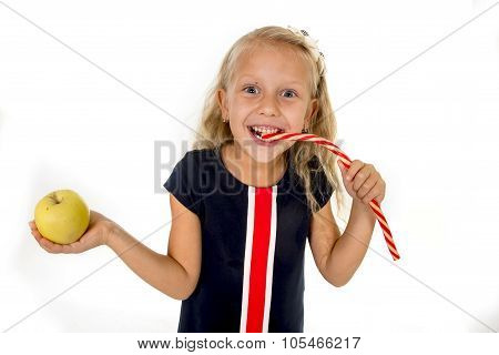 Little Pretty Female Child Choosing Dessert Holding Unhealthy But Tasty Red Candy Licorice And Apple
