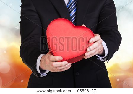 Young man holds red heart box