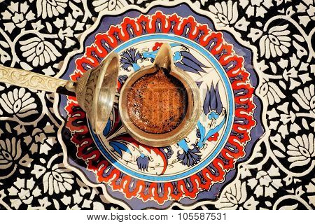 Turkish Cezve With Coffee On The Tablecloth With Ornaments