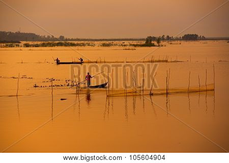 Fisher on boat in water season in sunrise in Dong Thap, Vietnam