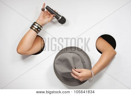Female hands with microphone and hat