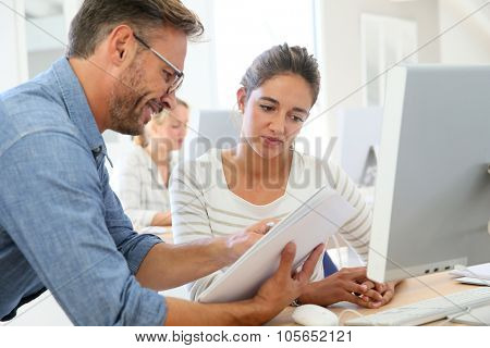 Teacher with student working on computer