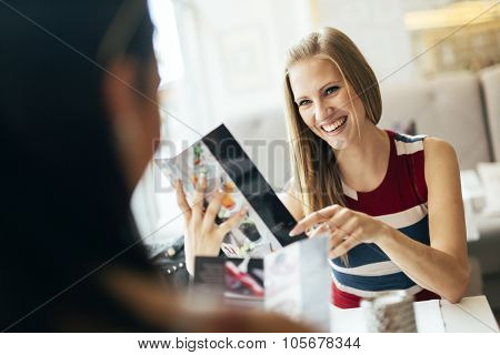 Beautiful Women Looking At Menu In Restaurant