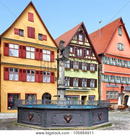 DINKELSBUHL, GERMANY - April 26, 2013: Colorful medieval houses with small shops and fountain on old square in Dinkelsbuhl