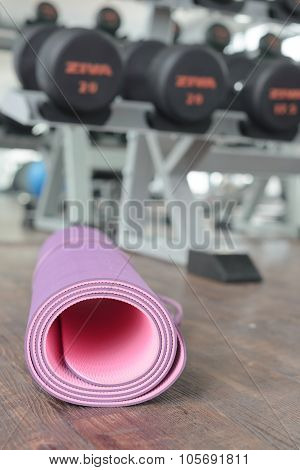 Close Up Of Rolled Yoga Mat On A Wooden Floor