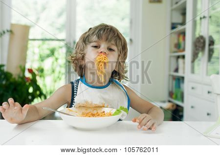 Little boy eating pasta