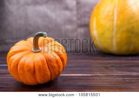 Two Pumpkins Lie On A Table