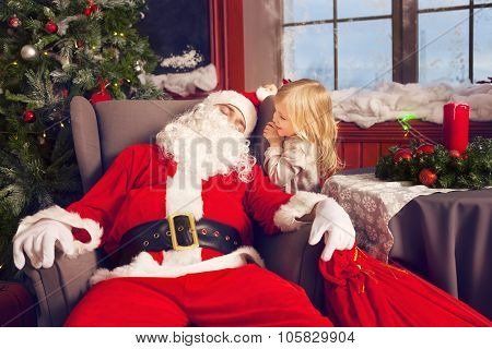 Photo Of Happy Littlle Smiling Girl Looking At Sleeping Santa Claus