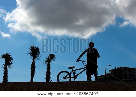 Silhouette of boy with bike