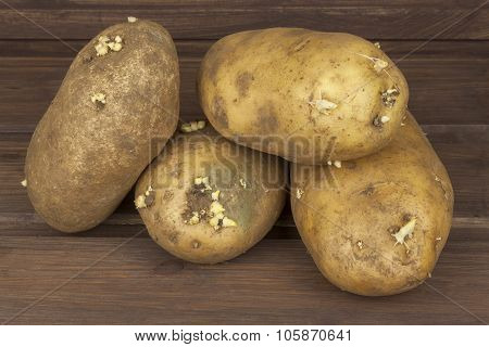 Freshly harvested organic potatoes on a wooden table. Growing domestic vegetables