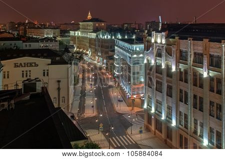Pyatnitskaya street with road, bike paths and sidewalks at night in Moscow. Text on wall - bank