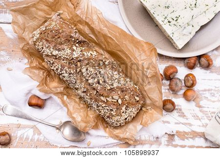 Bread With Seeds Cheese And Huzelnuts On Wooden Board