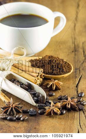 Coffee On The Cup With Coffee Beans And Cinnamon Sticks On Wood Background, Warm Toning, Selective F