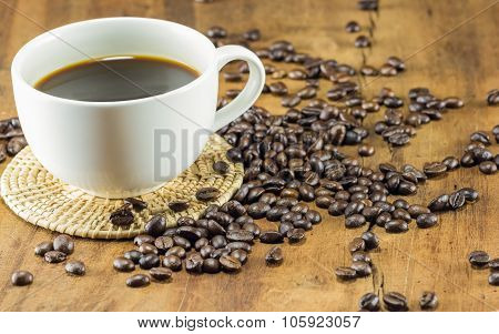 A Cup Of Coffee And Coffee Beans On Wood Background, Warm Toning, Selective Focus