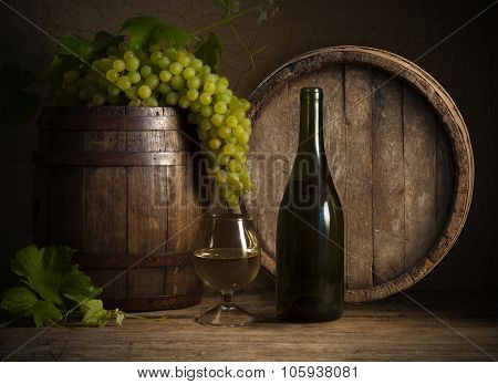 Glass white wine and bunch grapes on background of wooden