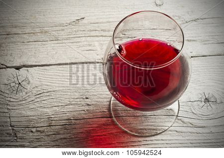 Glass white wine and bunch grapes on background of wooden