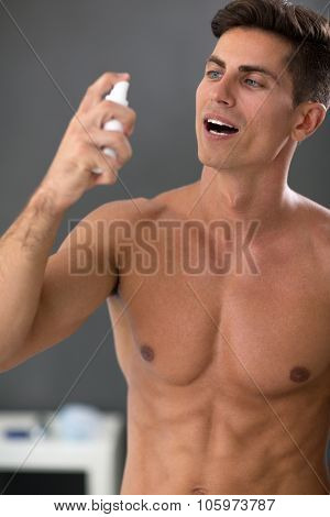Young handsome man using mint breath spray