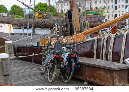 Bicycles Standing On The Quay Near The Exhibits Of The Netherlands Maritime Museum In Amsterdam