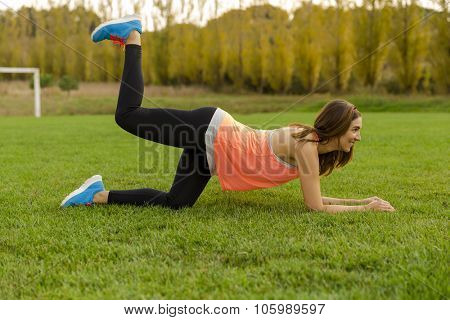 An attractive woman exercising outdoor on a soccer field