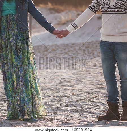 Lovely young couple on the sunset beach