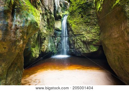 Waterfall Maly Adrspassky vodopad in the rock mountain Adrspasske skaly in Czech republic