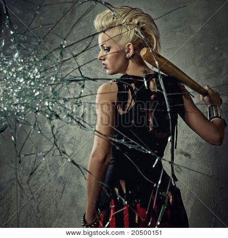 Punk meisje met een vleermuis achter gebroken glas