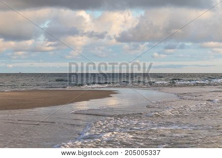 Waves of Skagerrak and Kattegat meeting at Grenen, Skagen, the most northern point of Denmark. Blue sky and white clouds