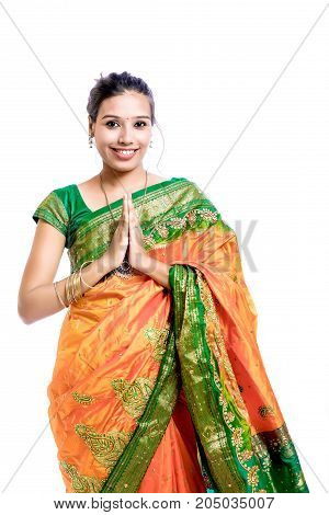 Happy young beautiful traditional Indian woman in traditional saree, Welcome Posing