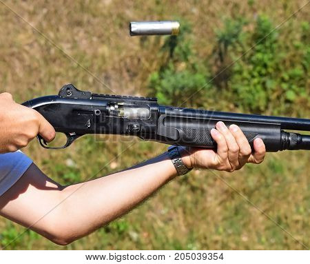 Shooting with a shotgun outdoor in summer