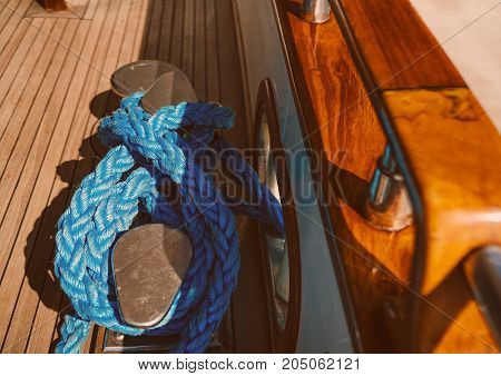 blue rope wrapped around a bollard on the deck of the yacht.