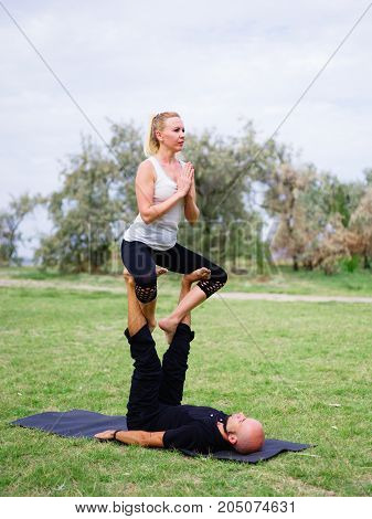 Photo of practicing yoga outdoor. Doing yoga fitness. Exercise for relax and healthy body.