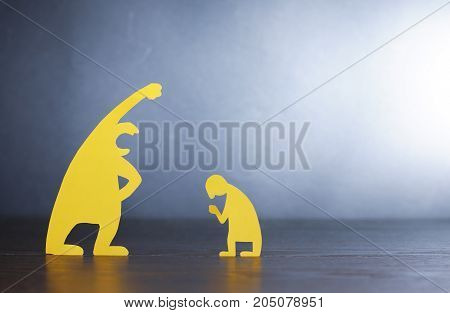 Big screaming man against small miserable man made from yellow paper