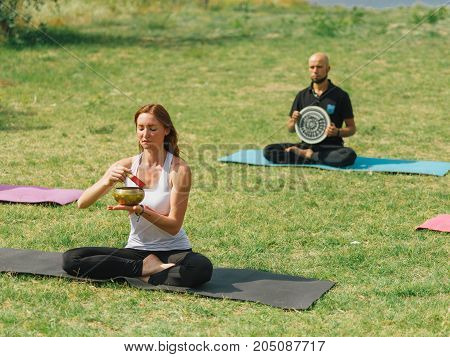 People at the health club outside with personal trainer, learning the correct form.