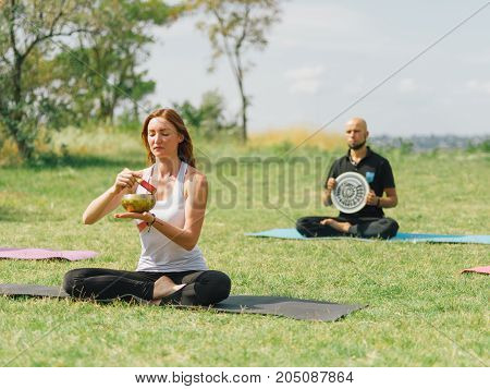 People at the health club outside with personal trainer, learning the correct form.