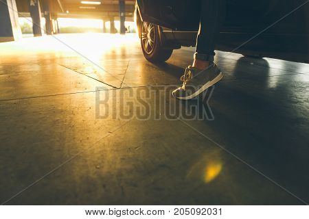 young modern woman get out of the car on parking on sunset