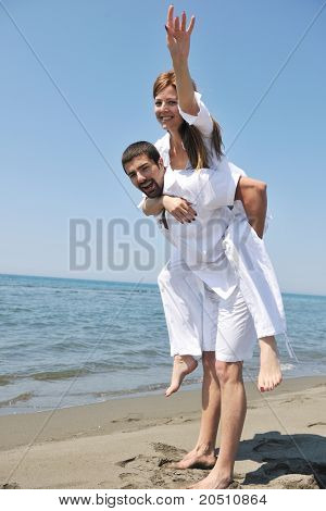 Szczęśliwa młoda para miłej zabawy i romantyczne chwile na plaży w sezonie letnim i reprezentujących happynes