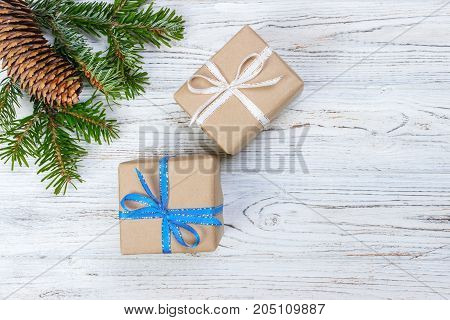 Christmas gift box on the white wooden table backgroundspruce branchpine conesframetop view space for text.
