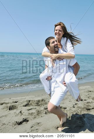 Szczęśliwa młoda para miłej zabawy i romantyczne chwile na plaży w sezonie letnim i reprezentujących happynes