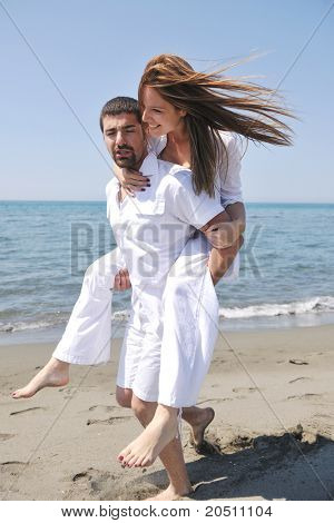 Szczęśliwa młoda para miłej zabawy i romantyczne chwile na plaży w sezonie letnim i reprezentujących happynes