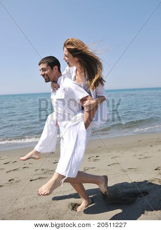 Szczęśliwa młoda para miłej zabawy i romantyczne chwile na plaży w sezonie letnim i reprezentujących happynes