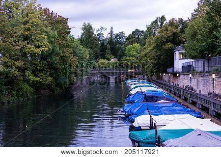 small boats in canal with tree and water reflection for fishing and sailing with raincovers at evening