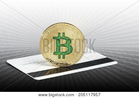 Cryptocurrency physical green bitcoin coin over the credit card.