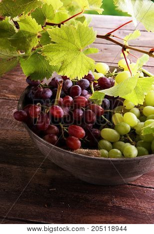 Grapes on wooden table and grape leaves . Healthy fresh fruit wine grapes.