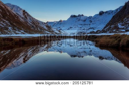 Snowed mountain reflection in the river in Pirineos