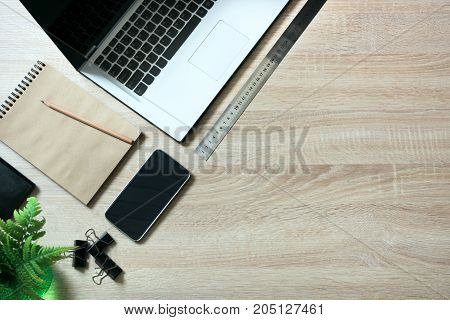 Open laptop and messthetics objects on office wooden desk table. Top view and copy space.