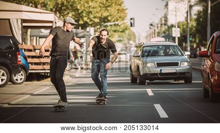 Two Skateboarders Riding Skateboard Slope On The City Streets