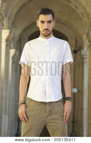 Street fashion concept. Portrait of elegant young handsome man. Paris buildings as background.